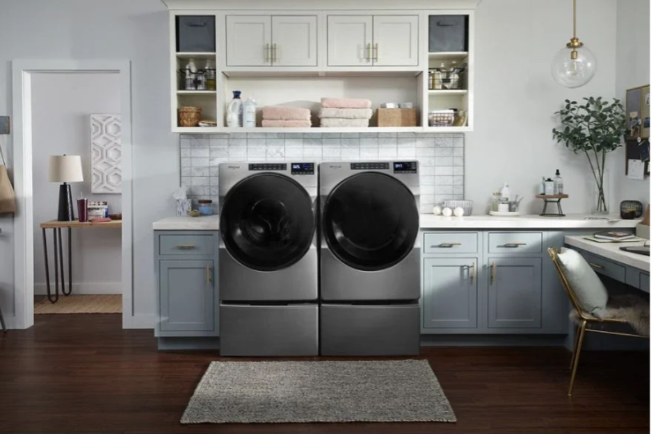 Whirlpool front load washer and dryer set installed in a modern laundry room. 